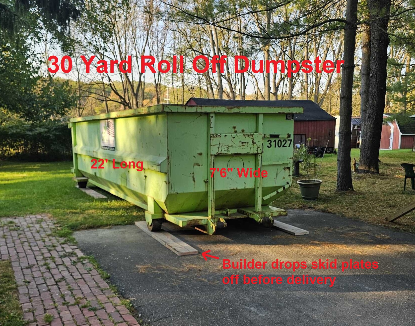 Roll off dumpster with skid plates on a driveway